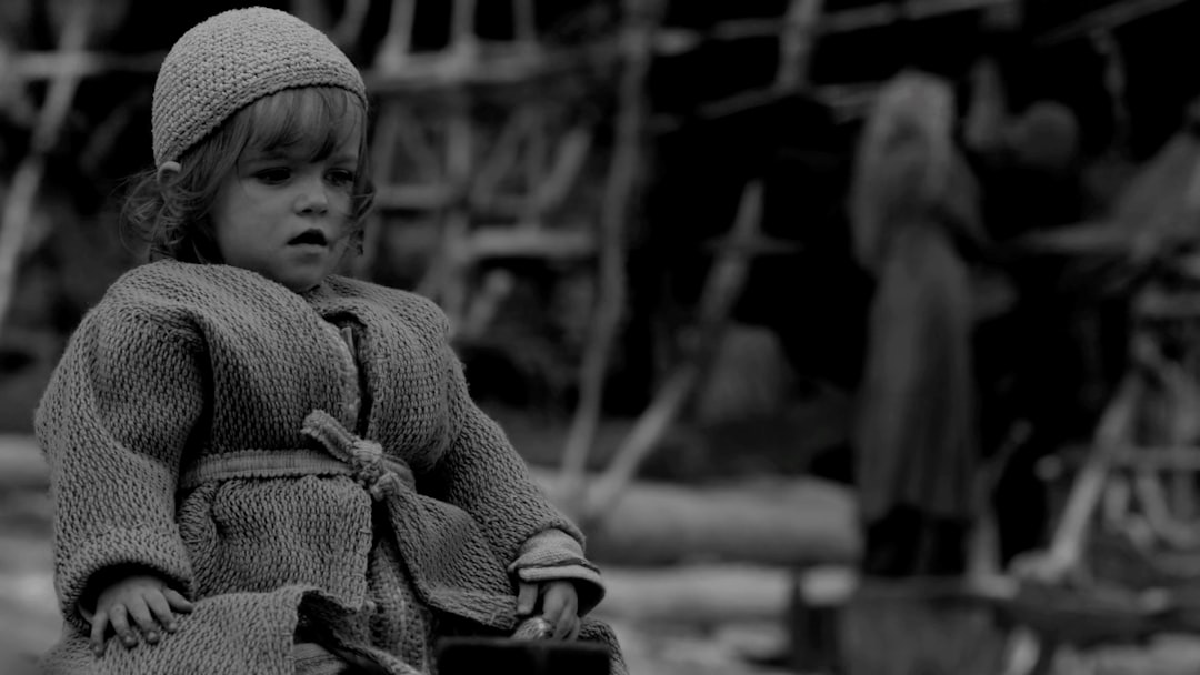 a little girl standing in front of a pile of clothes